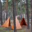 Փայտե Tipi Nature տնակները շրջապատված են անտառային ծառերով մանկապարտեզի բակում: