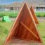Փայտե Tipi Nature տնակը դրսում կանաչ խոտածածկի վրա, խաղահրապարակում։