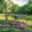 Outdoor Classroom կառուցվածքով,木ե նստարաններով, արևապաշտպան ճաղավանդակներով և մրգատուփերով բնական մի