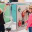 Երեխաները խաղում են բազմաֆունկցիոնալ Sensory Box մանկական խաղային սարքի մոտ: