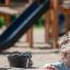 Sand & Water Play Nature պլաստիկ մանկական աղյուսակ սեւ դույլով ու կապույտ սահնակով խաղահրապարակում: